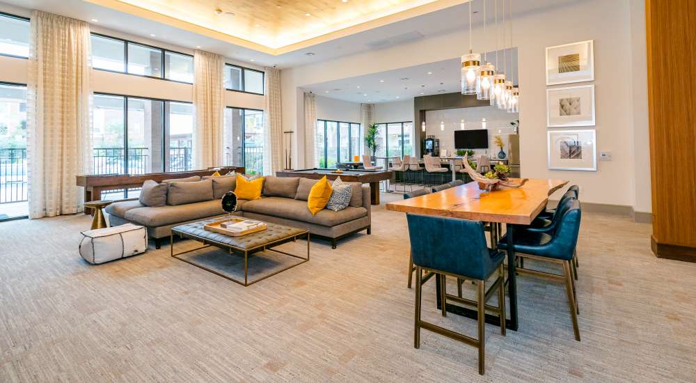 Clubhouse living area with leather couch and dining table at NOVU New Forest in Houston, Texas