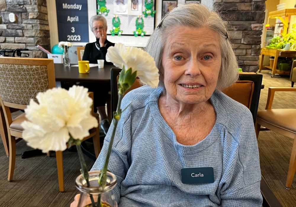 Resident holding a flower at Merrill Gardens at Tacoma in Tacoma, Washington