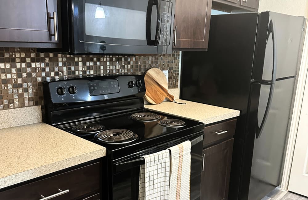 A model kitchen with black appliances at Walnut Ridge in Arlington, Texas
