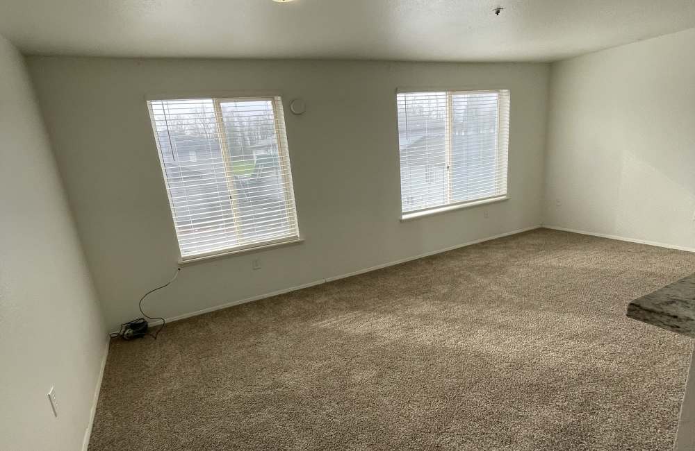 Living room with bright windows at Cherry Creek Apartments