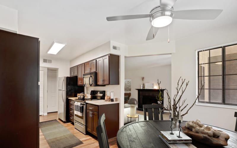 Renovated kitchen with espresso cabinets and stainless steel appliances , dining room and living room view at Royal Ridge Apartments in Midvale, Utah