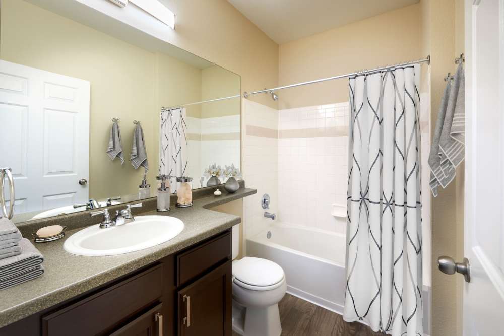 Bathroom with a bathtub and mirror at Skyecrest Apartments in Lakewood, Colorado