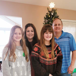 Employee's Family Standing in front of a Christmas Tree