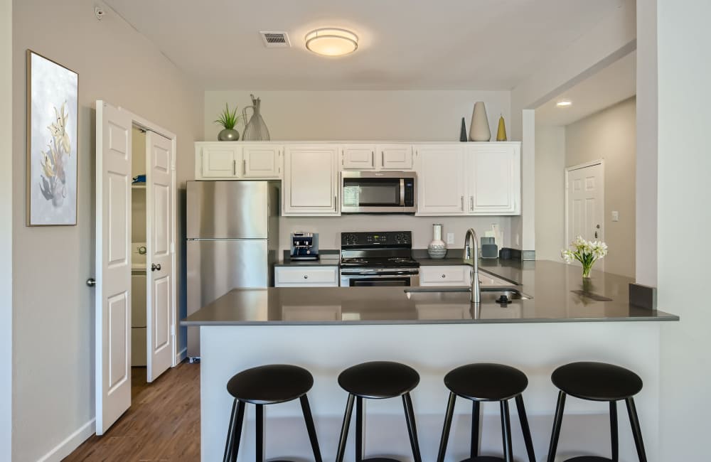 Fully equipped kitchen with steel appliances, breakfast counter and stools at Ascent at Lake Worth in Fort Worth, Texas