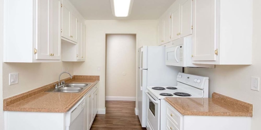 Kitchen with wood-style flooring at Bayfair Apartments in San Lorenzo, California