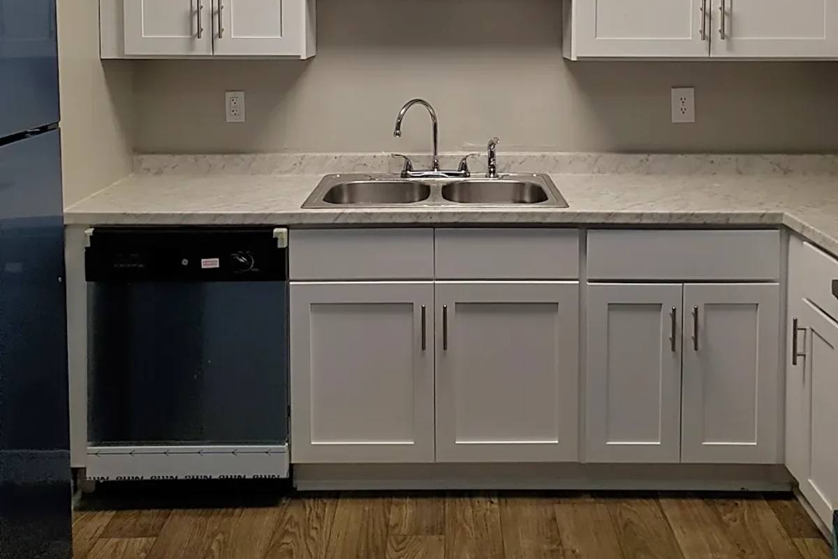 Kitchen with dishwasher and white cabinet at Alston Arms Apartments in North Charleston, South Carolina