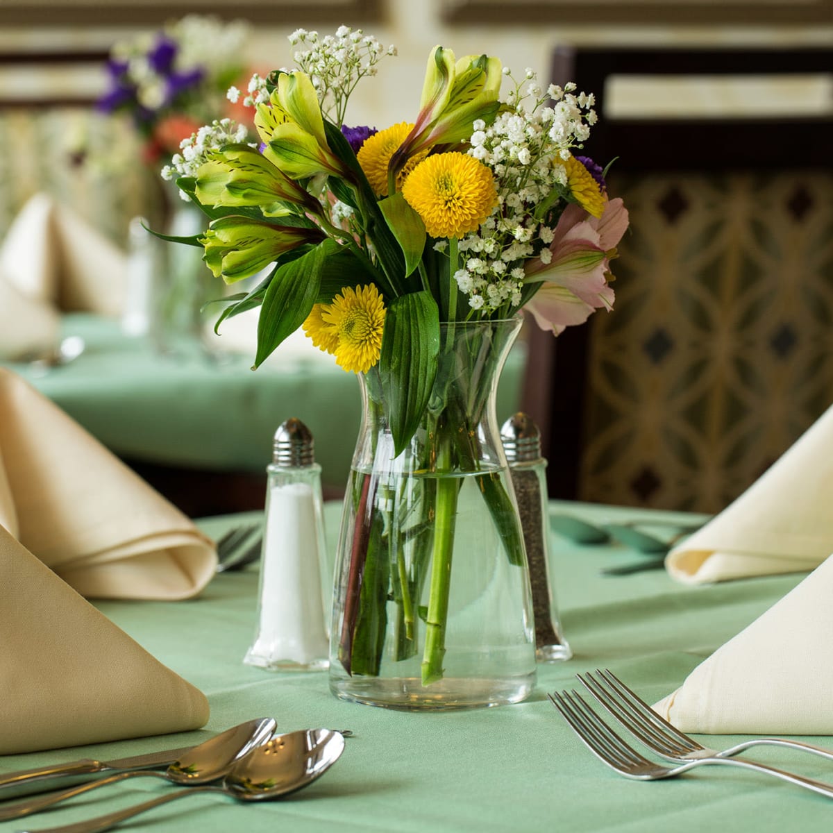 Community dining tables next to a kitchen at The Village of the Heights in Houston, Texas