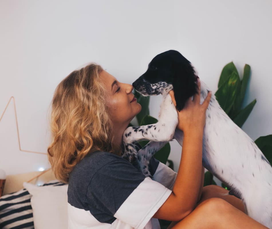 Resident giving her puppy a kiss in their new home at Veranda La Mesa in La Mesa, California