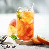 Glass of peach iced tea garnished with fresh peach slices at Athena Apartments in Benbrook, Texas