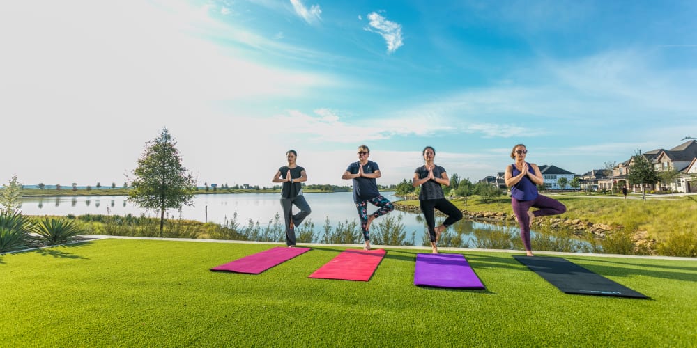 Residents doing yoga on the grass at BB Living Harvest in Argyle, Texas