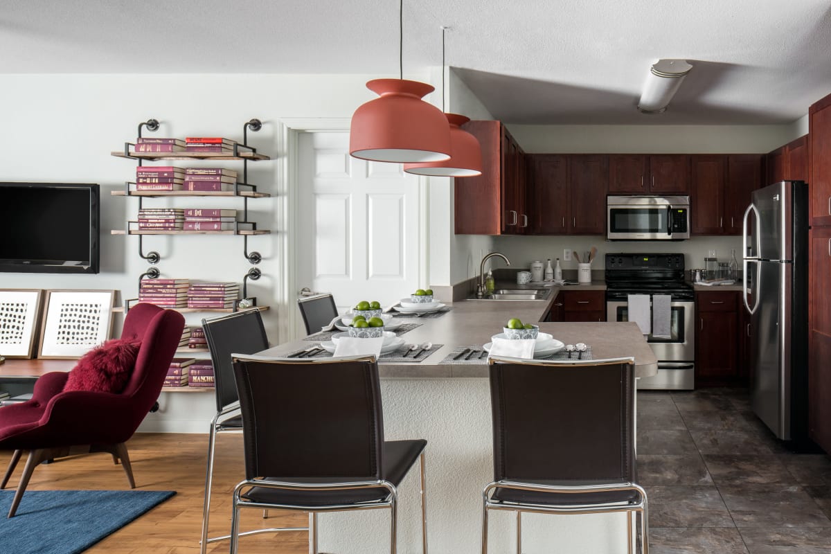 Gourmet kitchen with stainless-steel appliances, pendant lighting, and a breakfast bar at The Kristi in Corpus Christi, Texas