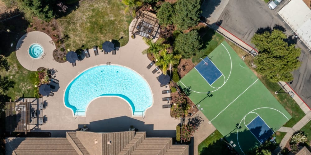 Aerial view of swimming pool, spa & sports court at Pinnacle at Galleria Apartments in Roseville, California