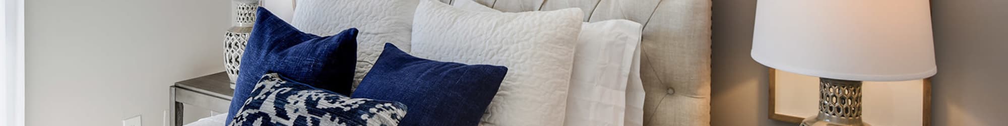 Queen size bed in model bedroom at The Alcove