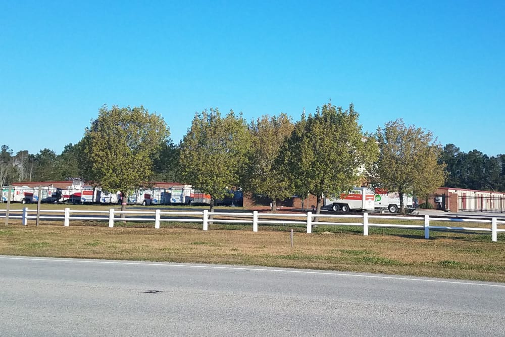 Tree-lined perimeter around storage units at Monster Self Storage in Ocean Isle Beach, North Carolina