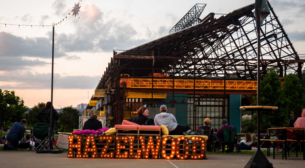 Lighted sign spelling hazelwood with seating near Woodlawn Lofts in Pittsburgh, Pennsylvania 