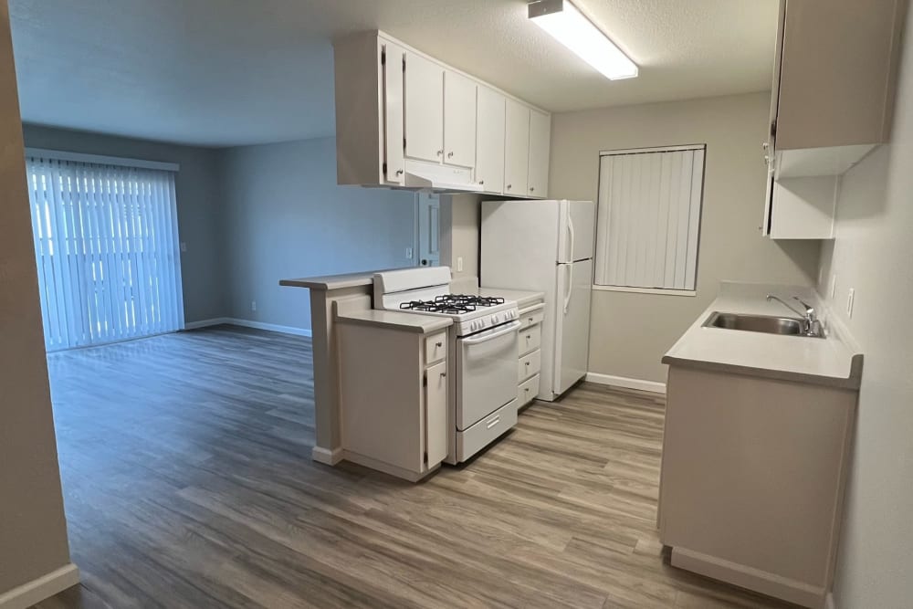 Minimalist White Kitchen with a view of the living room at Westwood Village Apartments in Manteca, California  