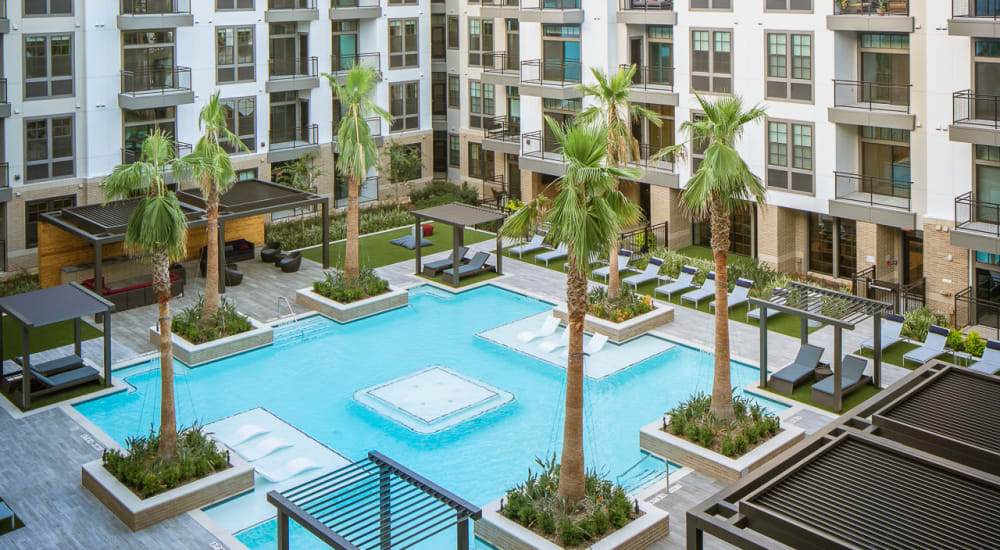 Community pool with palm trees at Bellrock Sawyer Yards in Houston, Texas