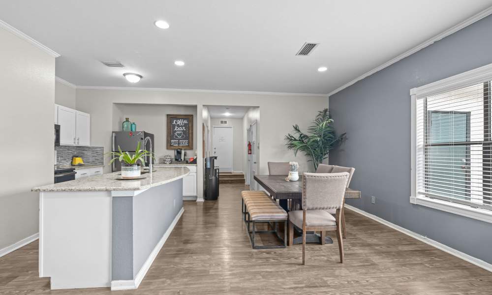 Community kitchen with dining space in the clubhouse at Pine Oaks Apartments in Mesquite, Texas