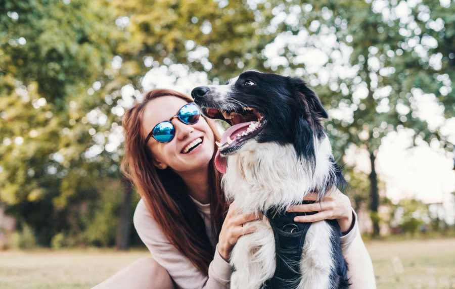 Happy woman hugging a pet dog outdoors at Cresta Bella in San Diego, California