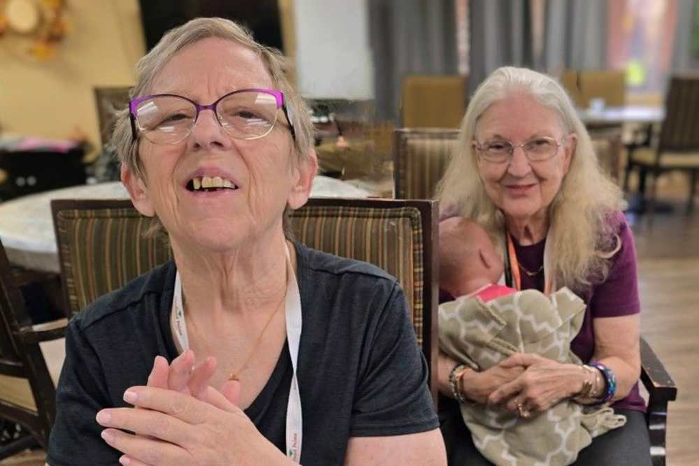 Ladies smiling at the camera at Woodland Palms Memory Care in Tucson, Arizona