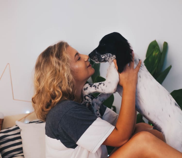 Resident giving her puppy a kiss in their new home at Sofi Sunnyvale in Sunnyvale, California