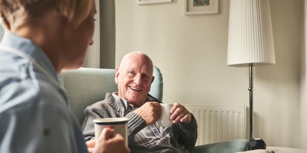 Resident talking to a caretaker over coffee at a WISH community