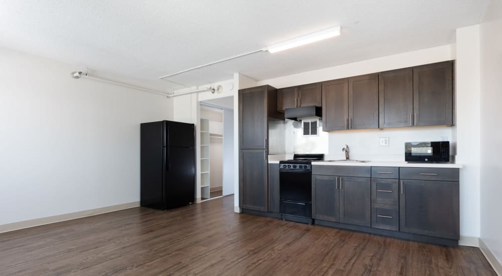 Open concept kitchen in an updated model apartment home with wood-style flooring at Golden West Tower Apts in Torrance, California