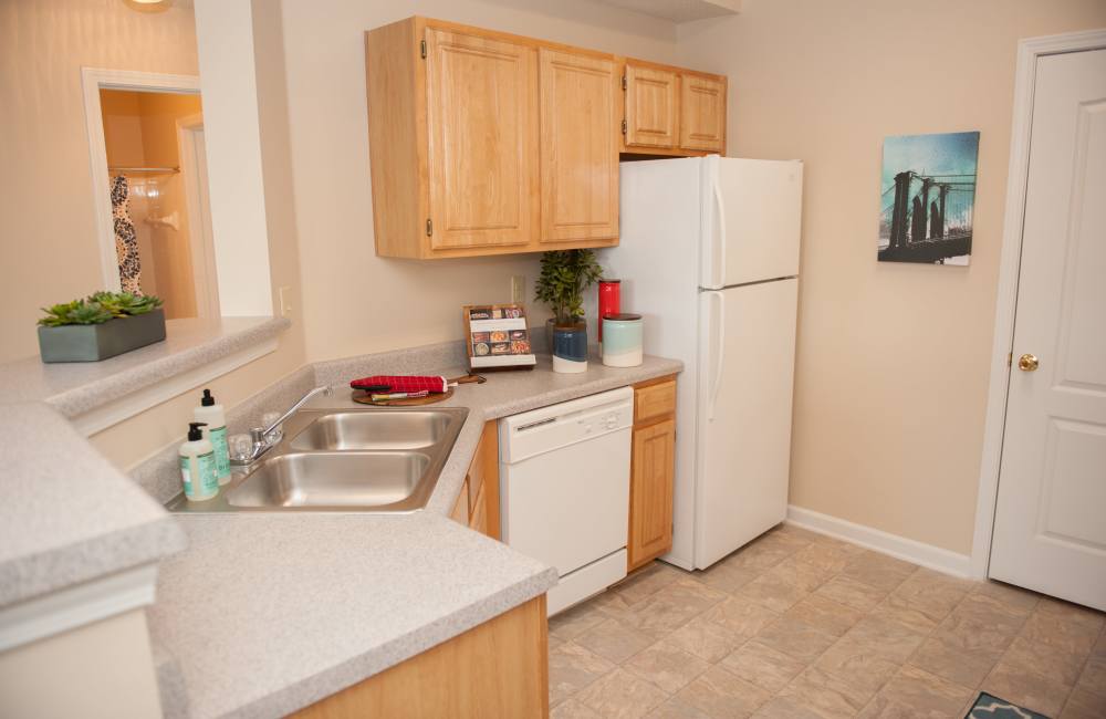 Cozy kitchen with white appliances including refrigerator, wooden cabinetry at Waterford Place Apartment Homes in Memphis, Tennessee