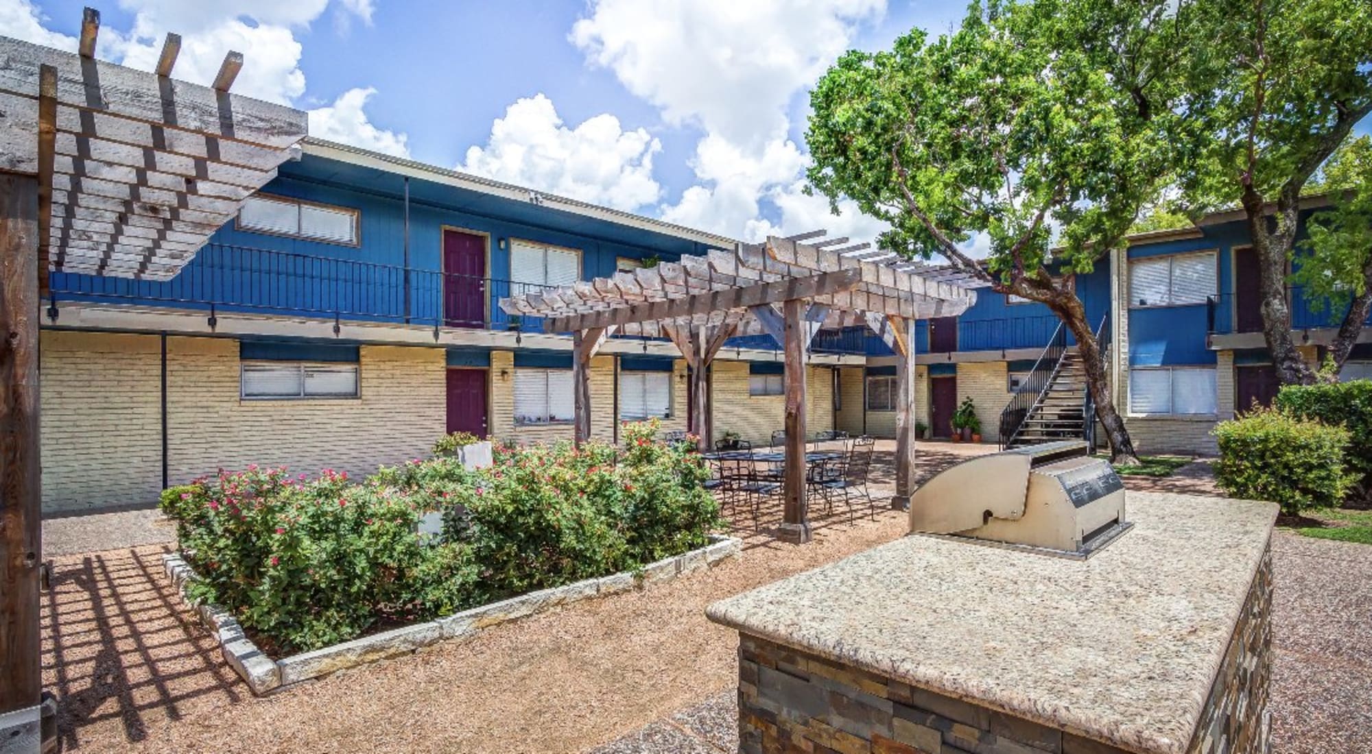 Courtyard with pergolas and grilling station at The Station in Houston, Texas