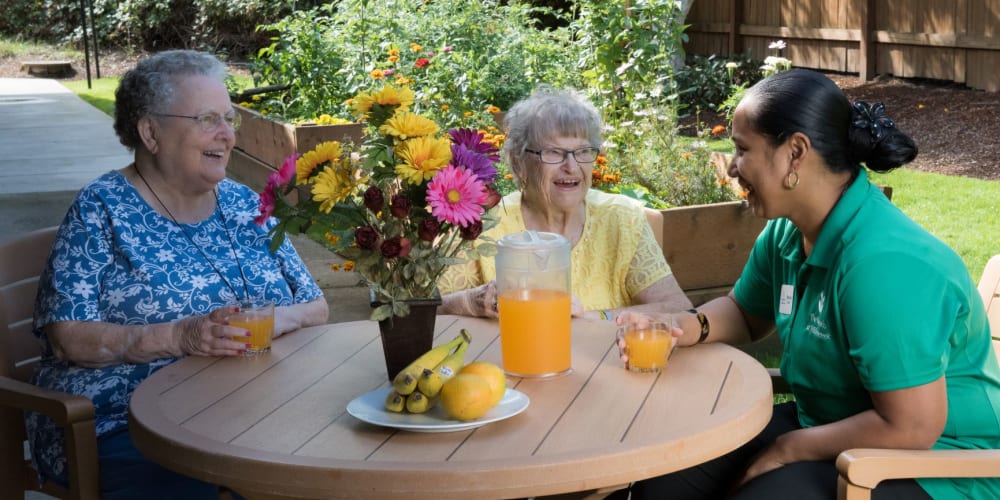 Residents enjoying a beverage with caregiver at The Springs at Willowcreek in Salem, Oregon