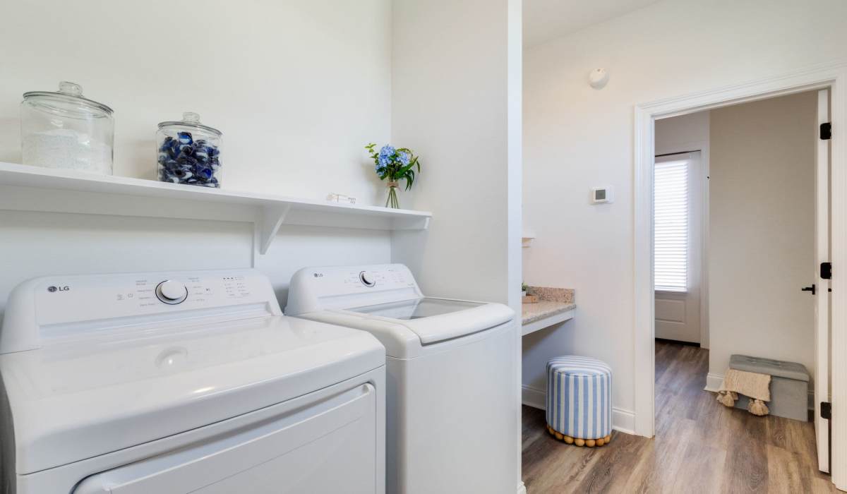 Bright laundry room with LG washer and dryer, granite countertop, and wood-style flooring at Lakewood Villas in Bossier City, Louisiana
