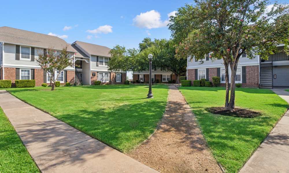 Exterior shot of the apartments with walking trails at Arbors of Taylor in Taylor, Texas