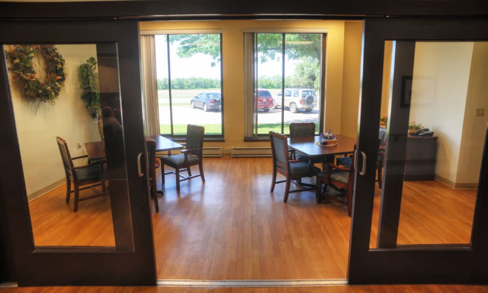 Intimate room with dining tables and large windows at East Troy Manor in East Troy, Wisconsin