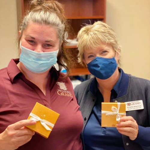Masked team members holding gifts at The Oxford Grand Assisted Living & Memory Care in McKinney, Texas