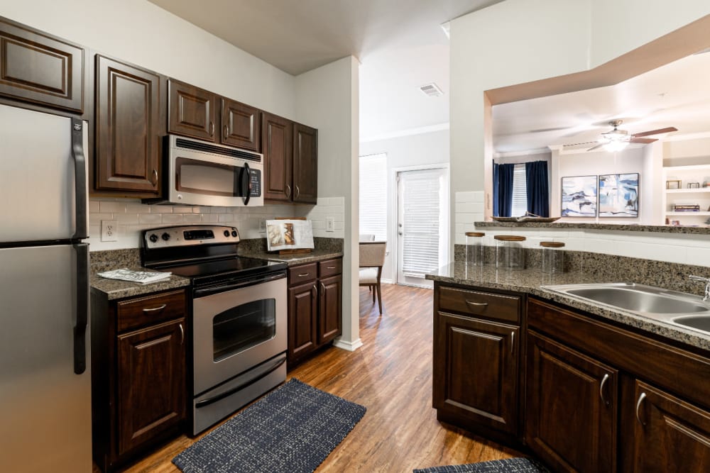 Modern style kitchen with granite counters at Marquis at Bellaire Ranch in Fort Worth, Texas