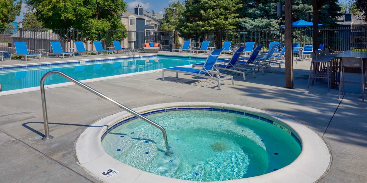 Beautiful resort-style swimming pool with lounge chairs and a barbecue area at Alton Green Apartments in Denver, Colorado