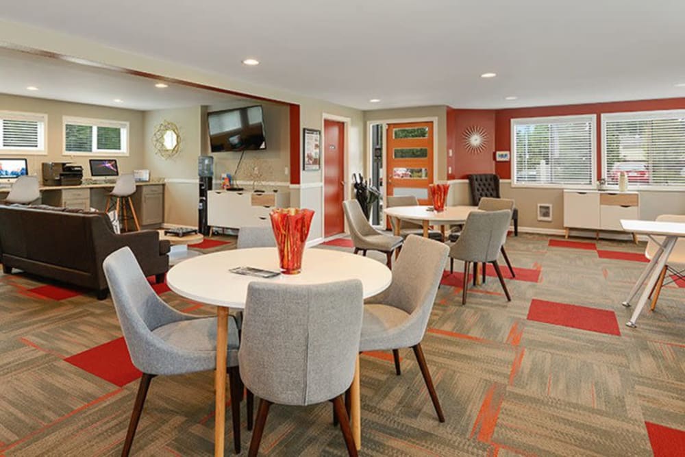 Multiple tables with chairs in community clubhouse at Terra Apartment Homes in Federal Way, Washington
