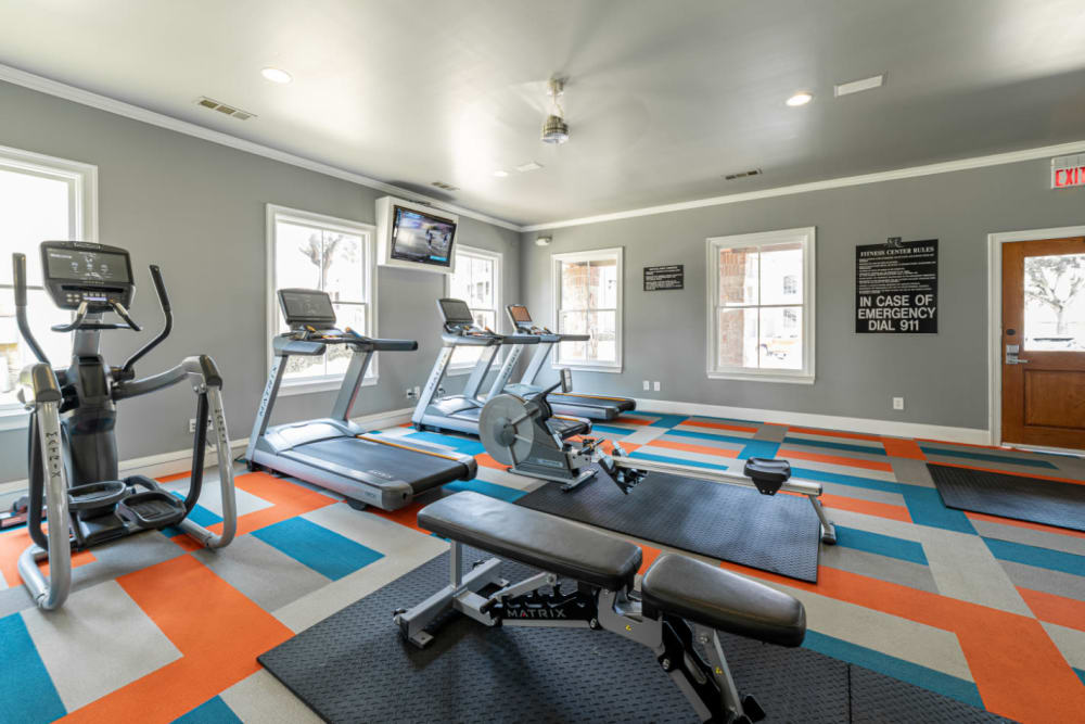 Treadmills, row machine, elliptical, and TV monitor in fitness room at Marquis at Bellaire Ranch in Fort Worth, Texas