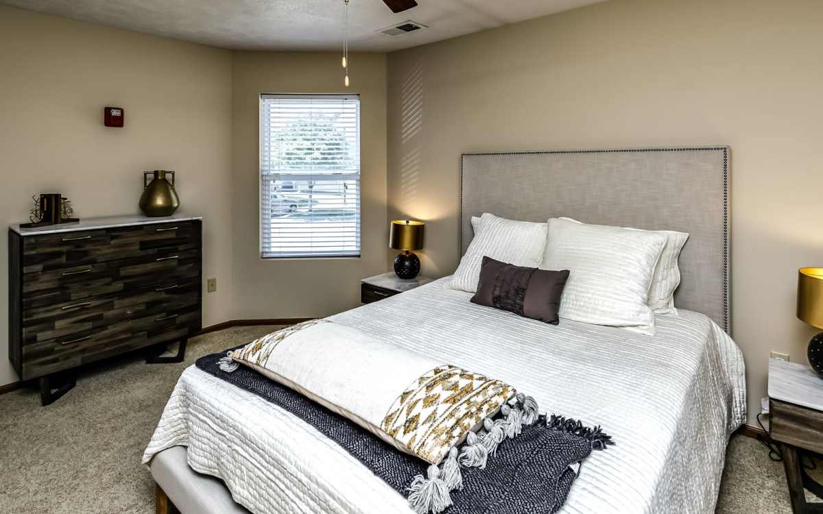 Model bedroom with comfortable bed at The Falgrove Apartments in Omaha, Nebraska