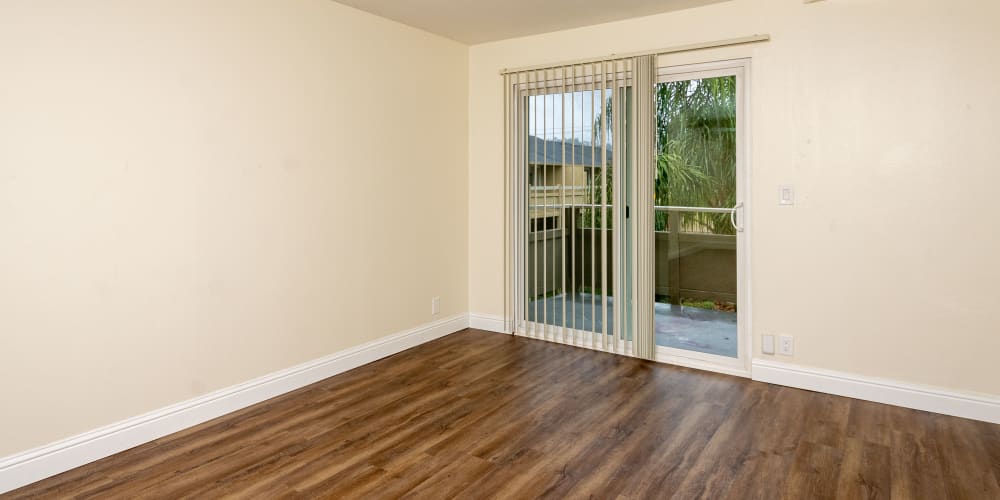 Wood-style flooring and door to the patio at Bayfair Apartments in San Lorenzo, California