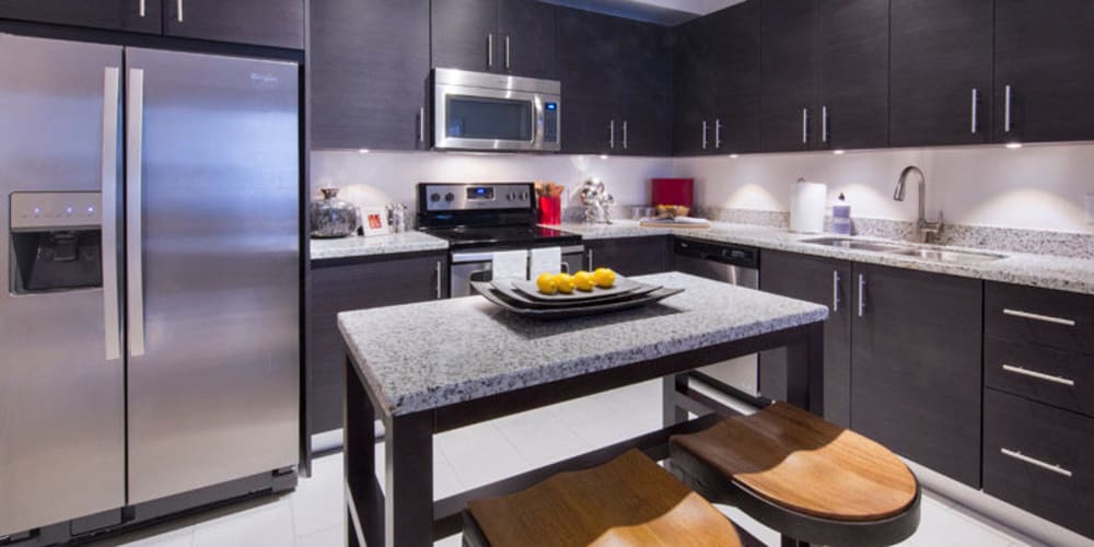 Modern gourmet kitchen with granite countertops in a model home at Doral View Apartments in Miami, Florida