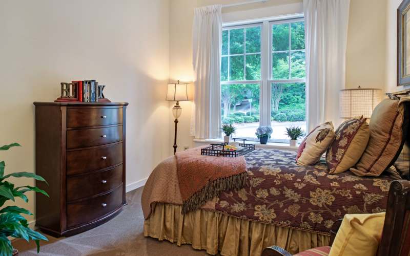 Spacious bedroom with large window and storage unit at Glenncrest at Buckhead in Atlanta, Georgia