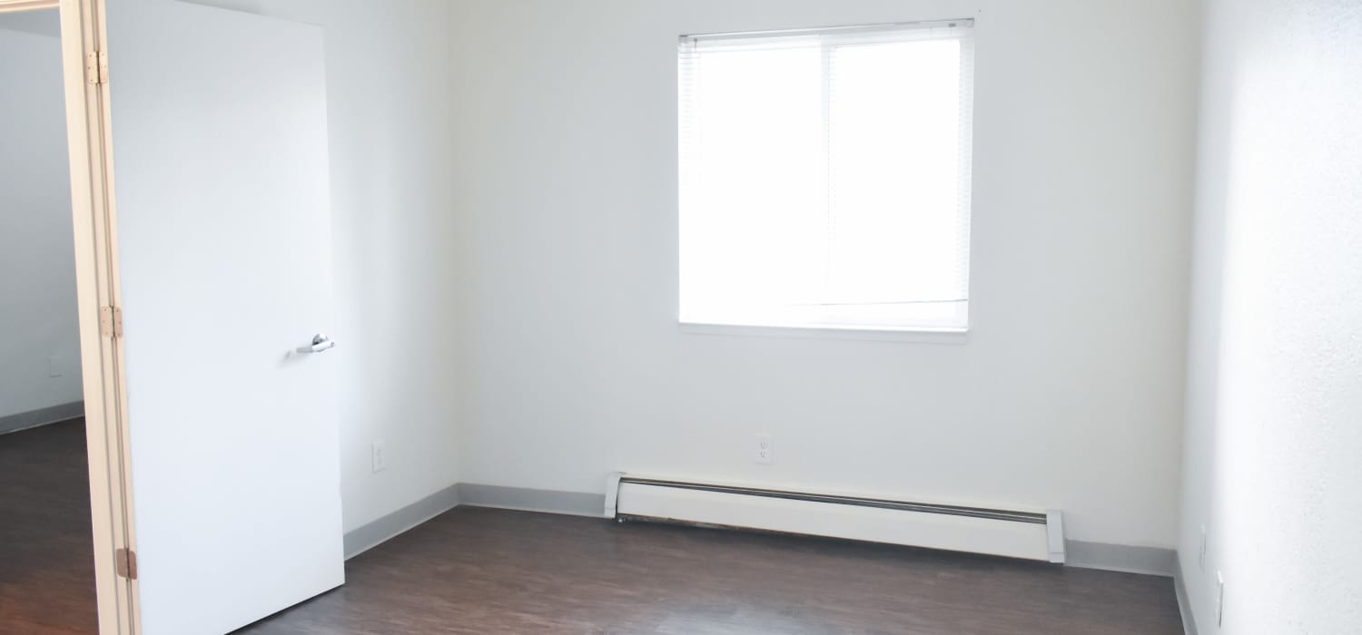 Apartment bedroom with hardwood flooring and a window at Clairewood Apartments in Saint Clair, Michigan