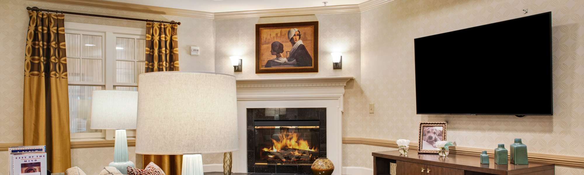 Cozy lounge with fireplace and comfortable seating at Glenncrest at Johns Creek in Johns Creek, Georgia