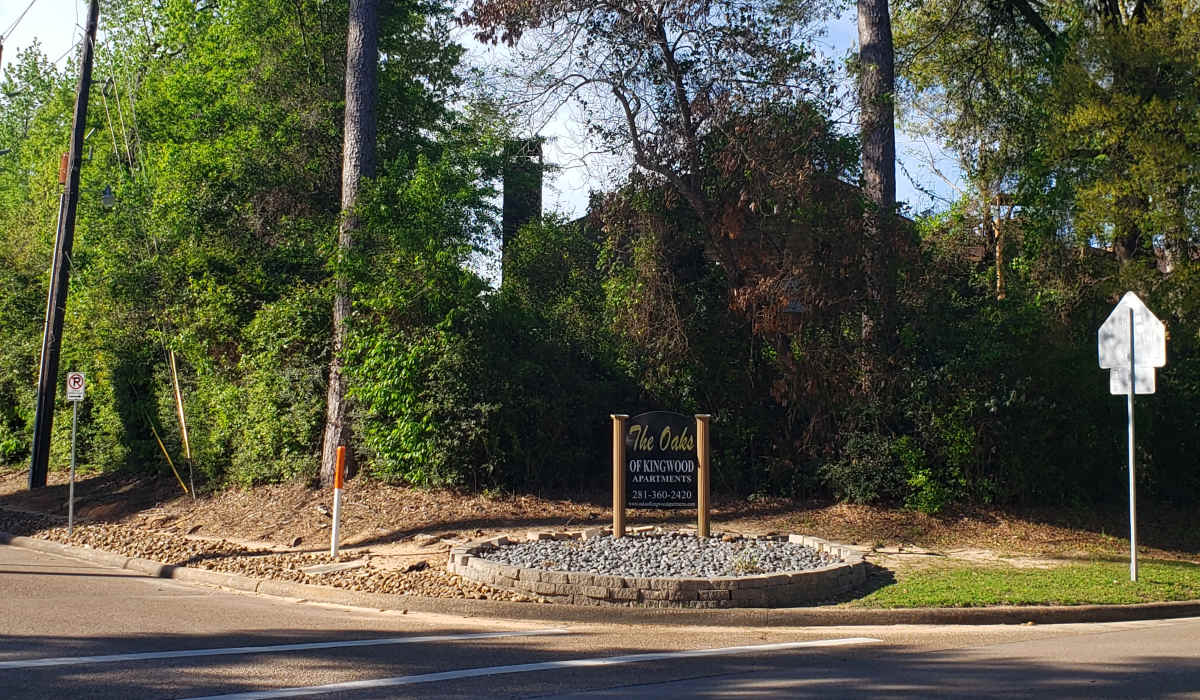 Community entrance sign at Oaks of Kingwood Apartments in Kingwood, Texas