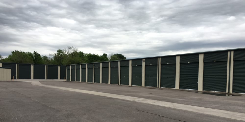 Outdoor storage units with green doors at StorQuest Self Storage in Richmond, Texas