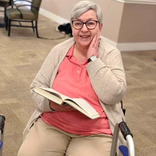 A smiling resident reading a book at FountainBrook in Midwest City, Oklahoma