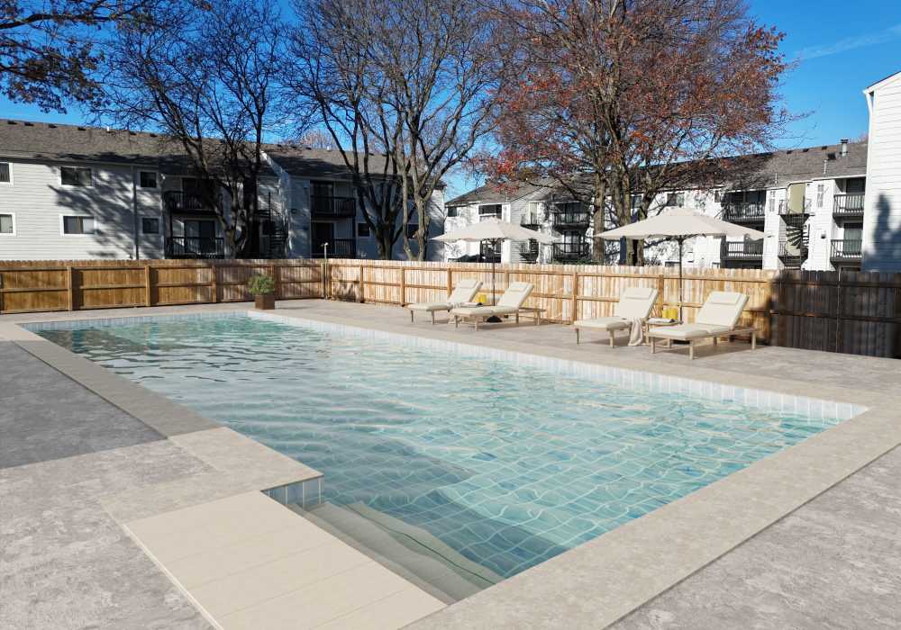 Swimming pool and apartment view with surrounded by trees at Rock Ridge Commons in Moline, Illinois