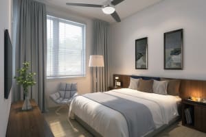 A furnished bedroom in an apartment with tall ceilings at The Flats at East Bay in Fairhope, Alabama