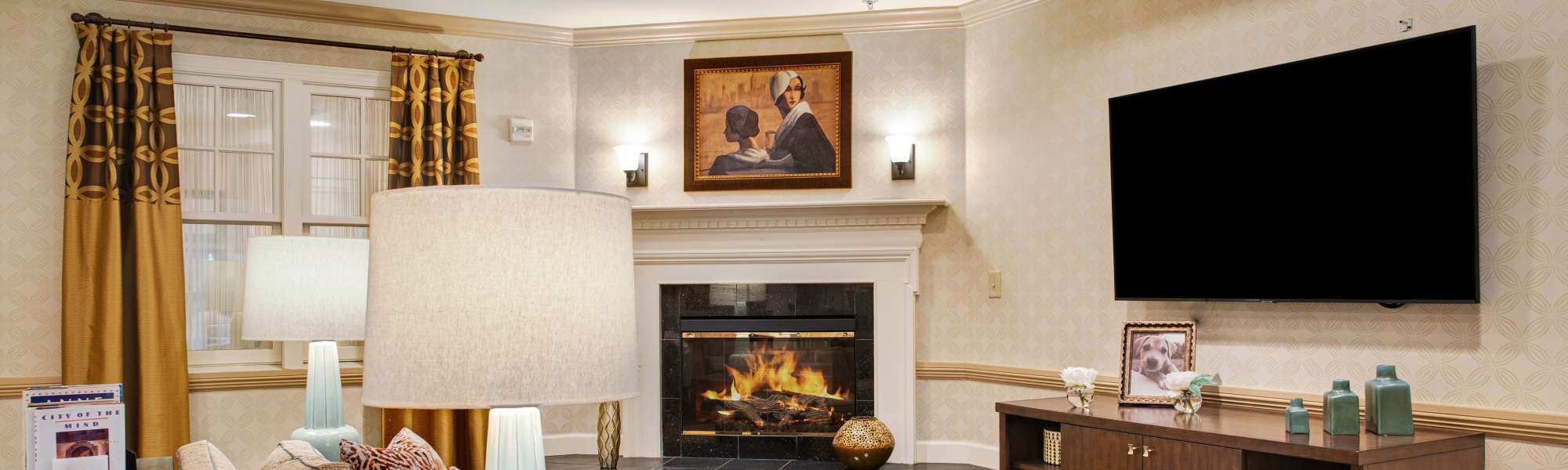 Cozy lounge with fireplace and comfortable seating at Glenncrest at Johns Creek in Johns Creek, Georgia